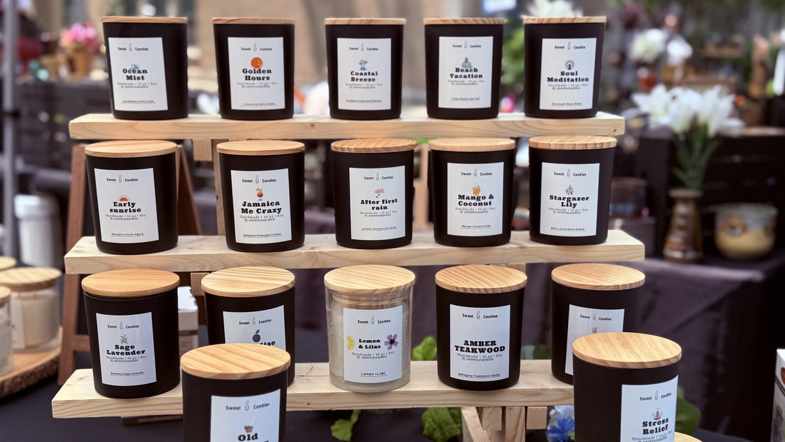 Sweet U Candles soy candles in matte black jars with wooden lids stacked on a wooden display shelf