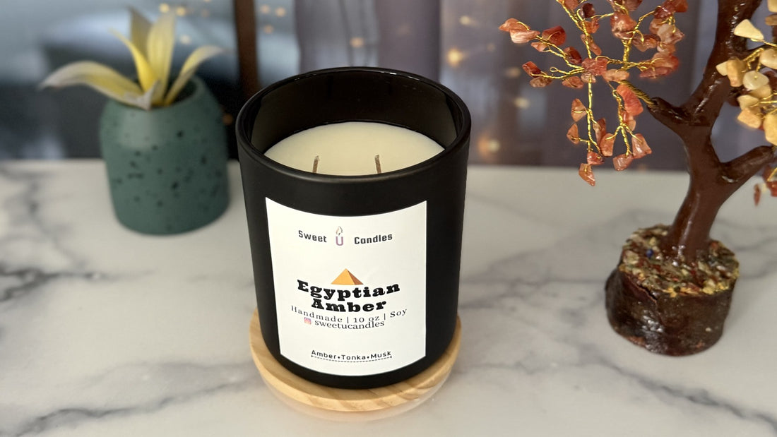 Sweet U Candles Egyptian Amber 10 oz soy candle on a marble surface with warm fairy lights, styled for summer